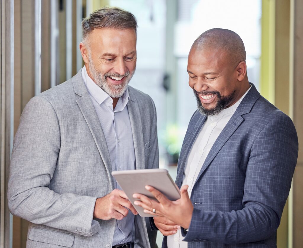 Happy businessmen looking at their business value increase on a tablet.