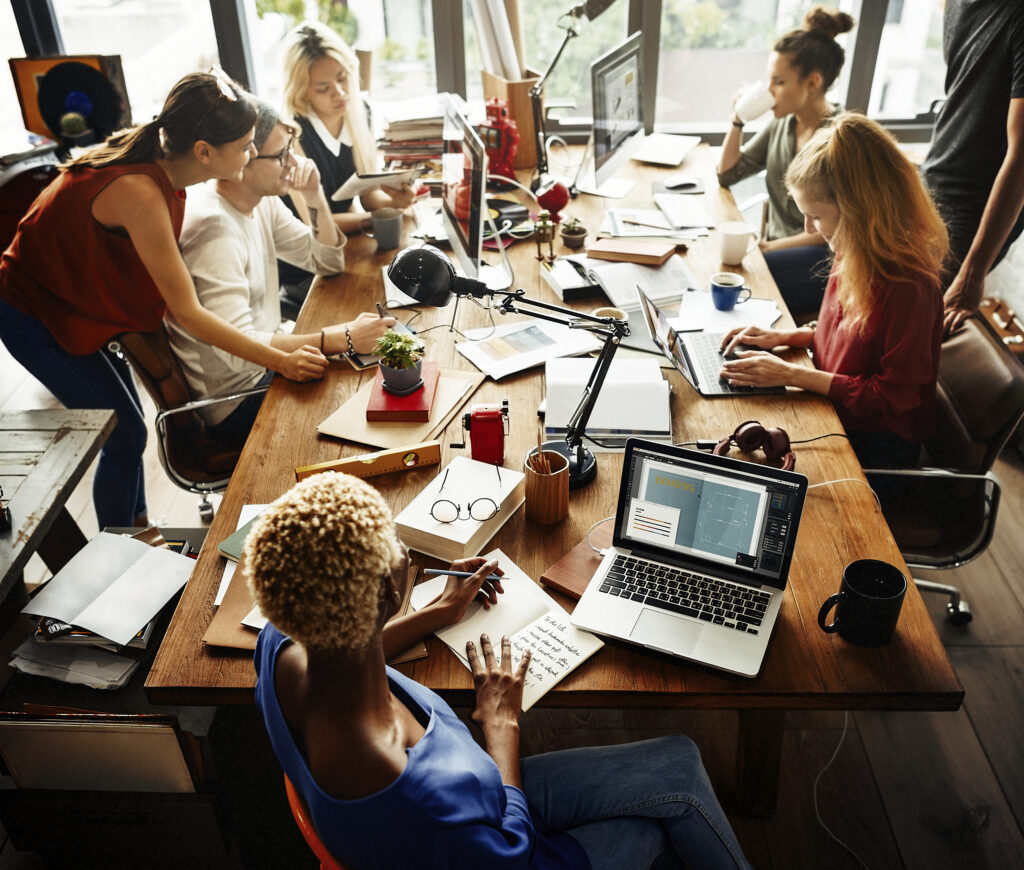 Newbern Excel professionals gathered around a shared workspace.