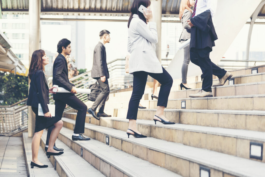 Professionals walking up steps together, symbolizing growth and progress during a career transition.